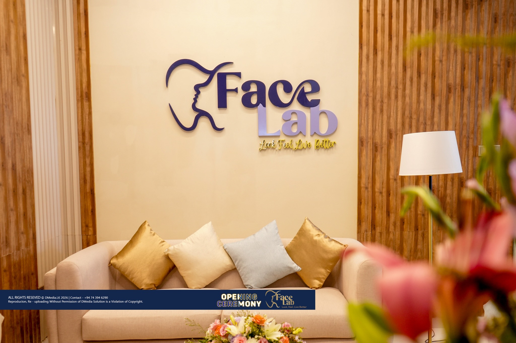 FaceLab reception lounge with the brand wall, sofa and floor lamp