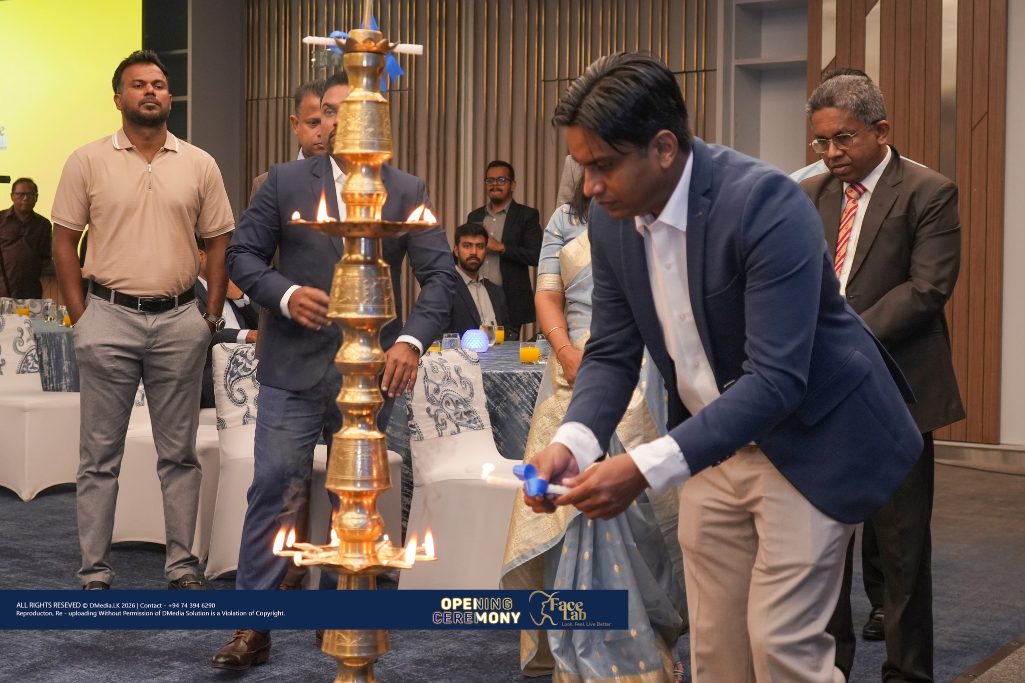 A FaceLab co-founder lights the ceremonial oil lamp as the team looks on